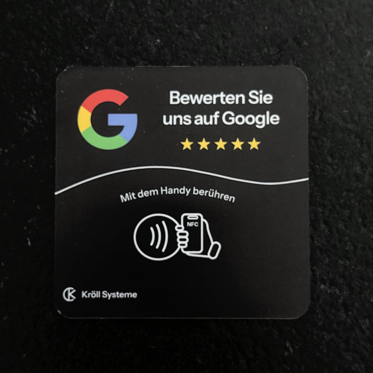 Bewertungsplatte für Google auf einem dunklen Tresen, frontal von oben
